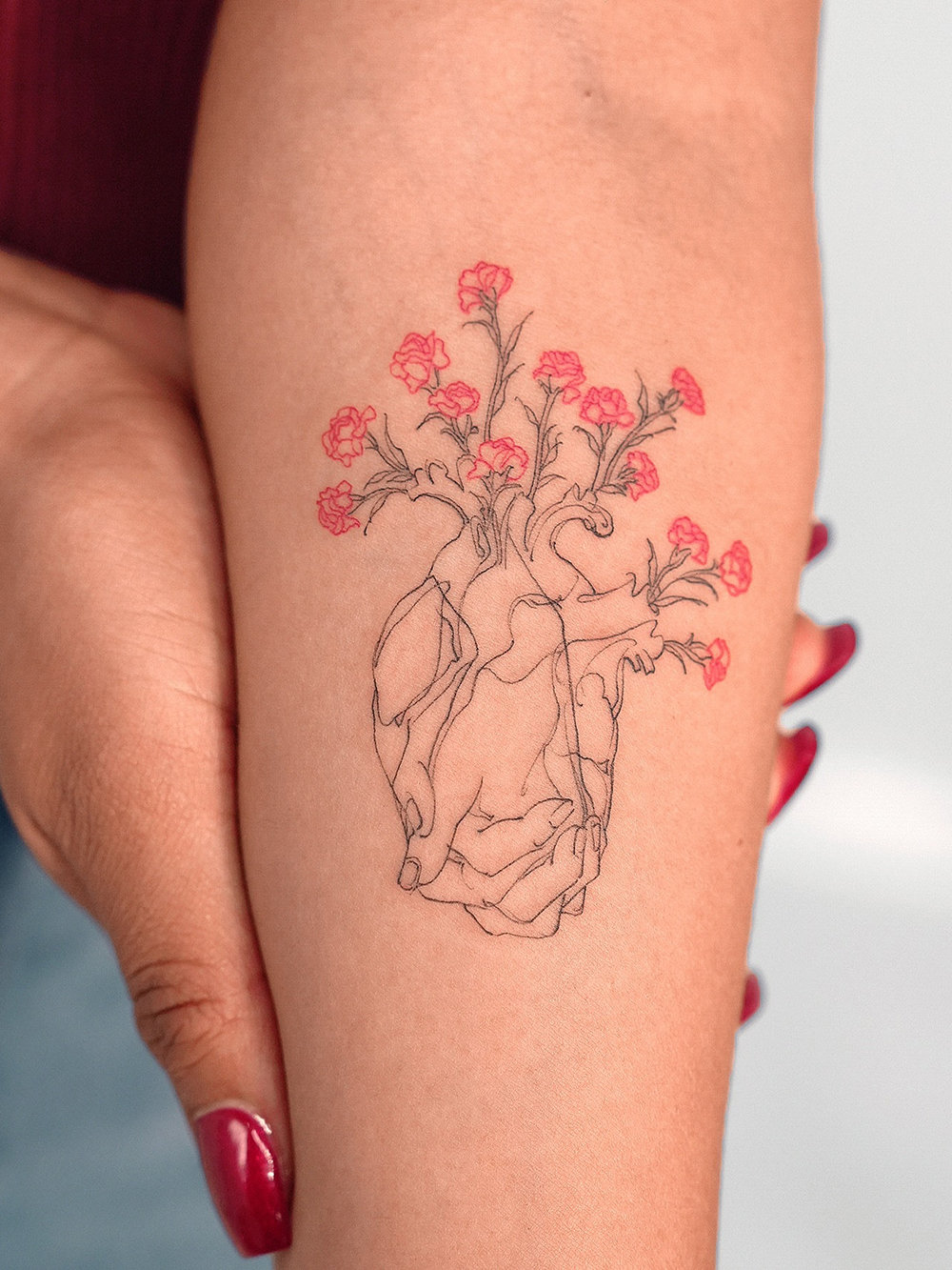 Heart tattoos made up of hands and flowers